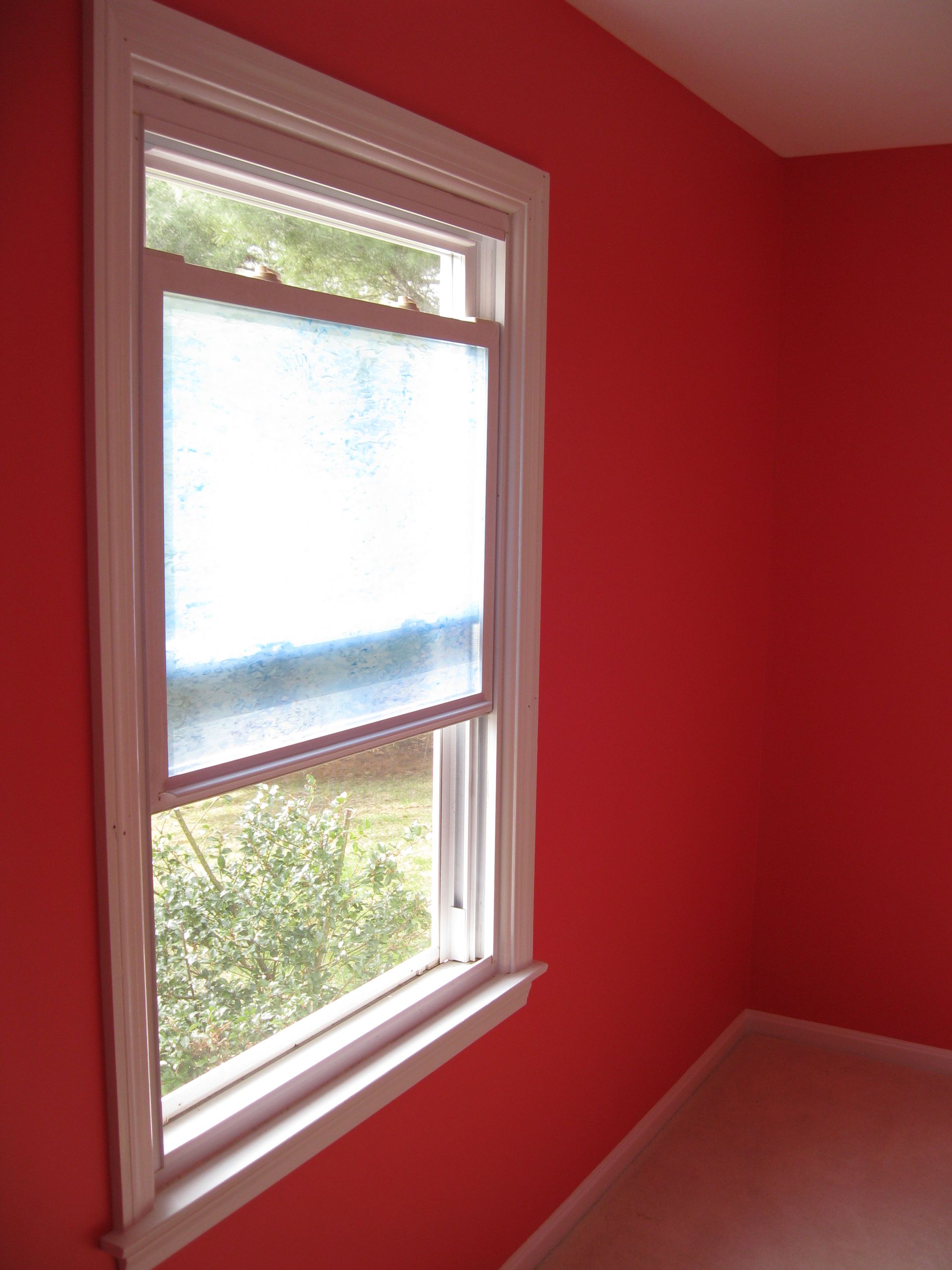 A window in a room with red walls