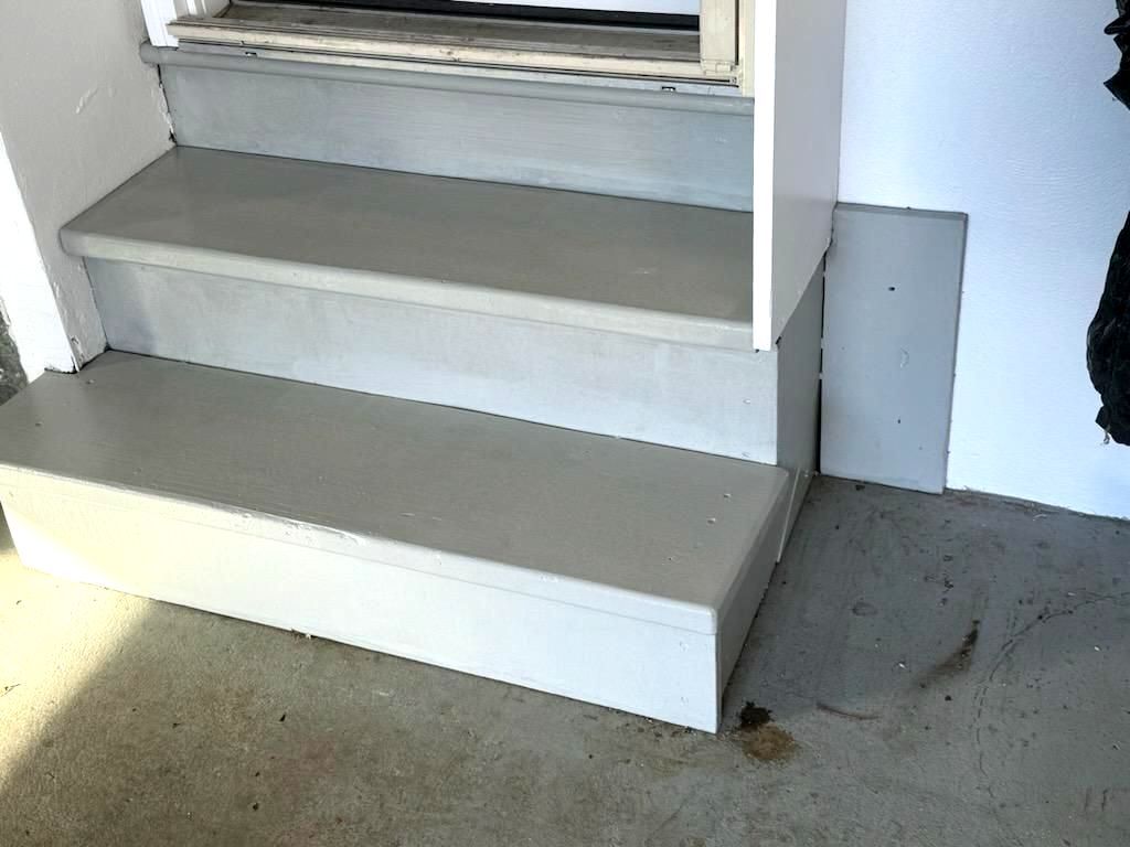 A set of stairs leading up to a window in a building.