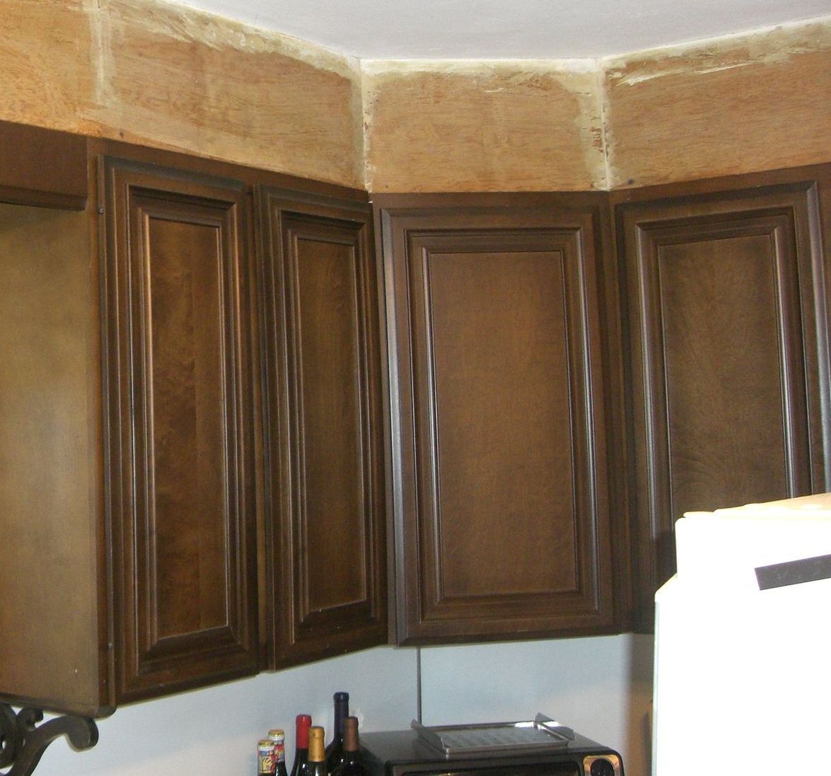 A kitchen with brown cabinets and a white refrigerator