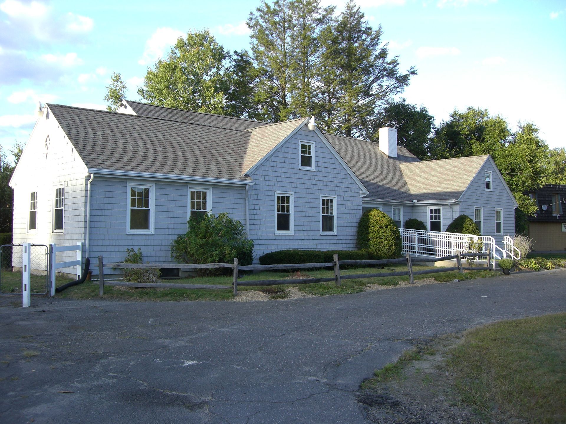 A large white house with a fence in front of it