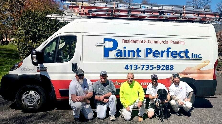 A group of men are posing in front of a paint perfect van