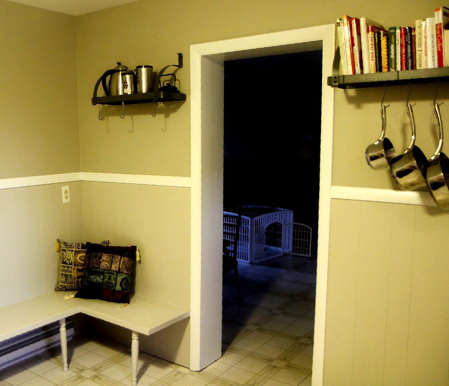 A kitchen with a shelf full of pots and pans