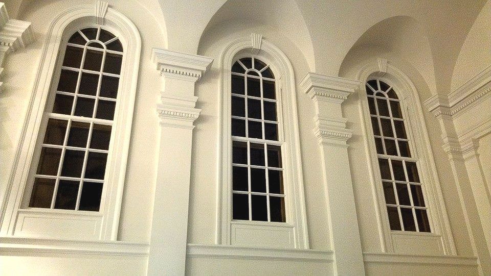 A row of arched windows on a white wall