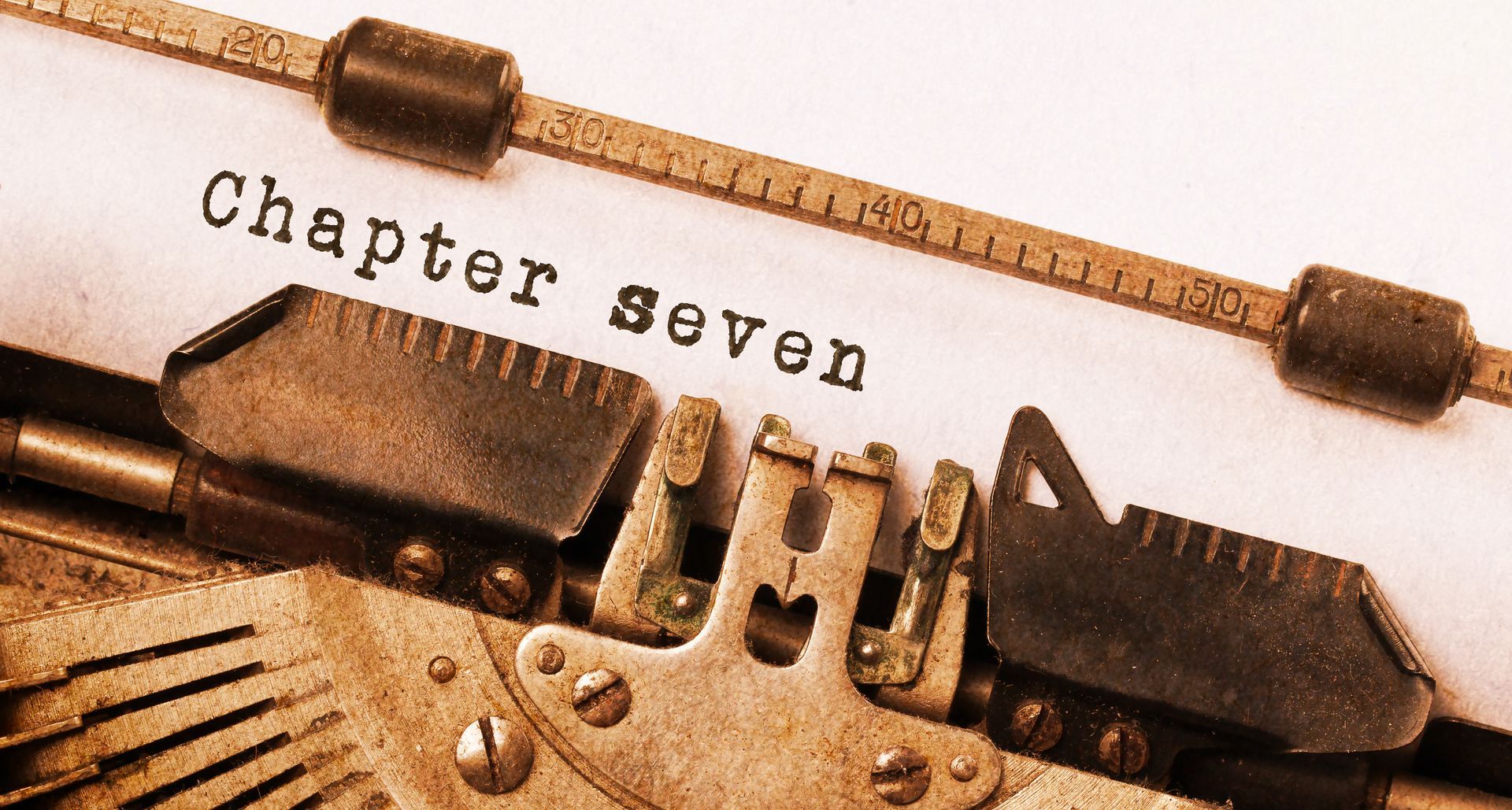 Vintage typewriter typing “Chapter seven” related to chapter 7 bankruptcy law documentation. Vintage typewriter typing “Chapter seven” related to chapter 7 bankruptcy law documentation.