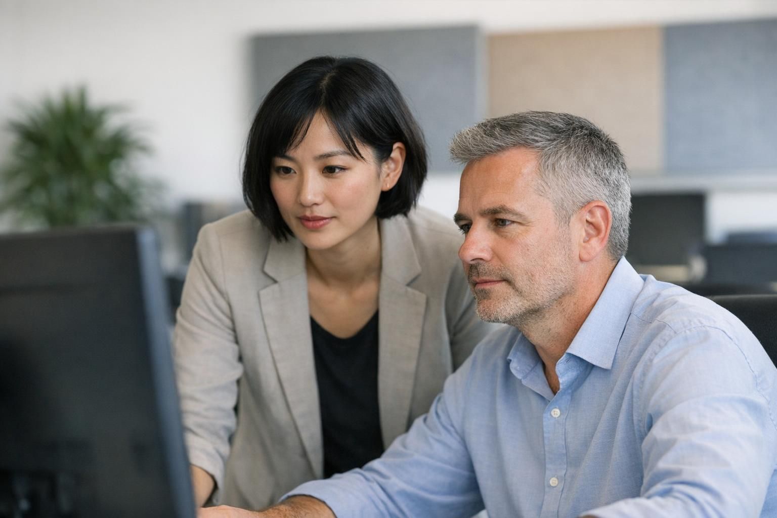 Zwei Personen besprechen IT Wartung und Systemüberwachung am Bildschirm