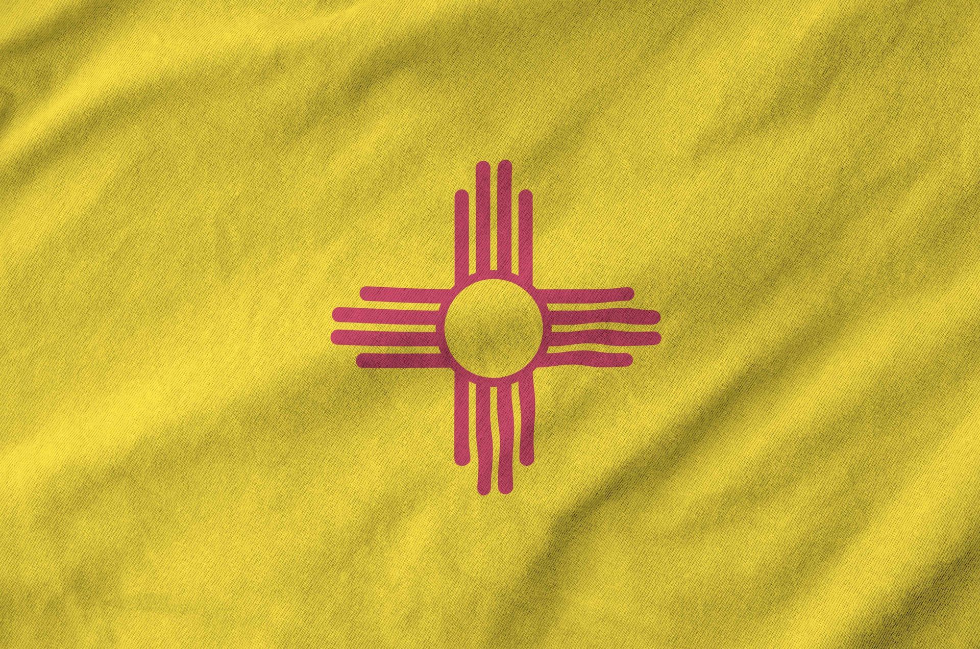 New Mexico state flag: Yellow field with a red Zia sun symbol in the center.