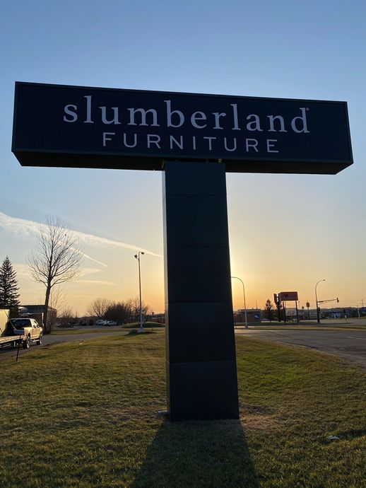 Slumberland Furniture roadside sign at sunset on a grassy median