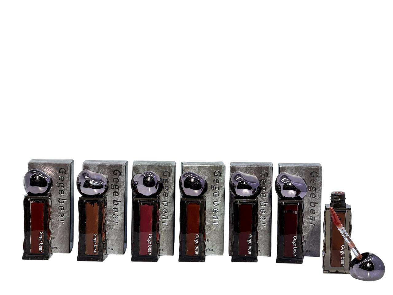 Seis frascos de perfume en cajas, dispuestos en fila. Cada uno contiene un frasco marrón oscuro