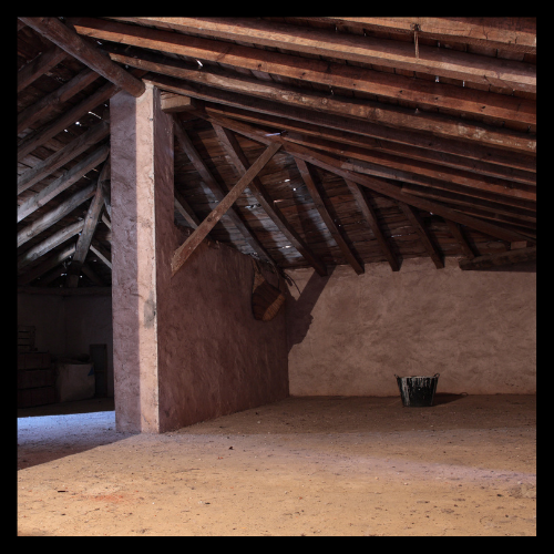 An attic with wooden beams on the ceiling
