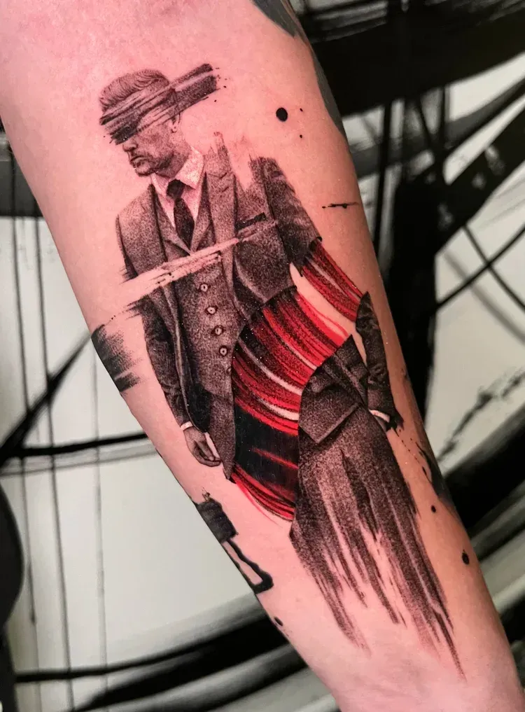 A forearm tattoo of a person in a suit, featuring a stylized glitch effect with bold red and black brushstrokes.