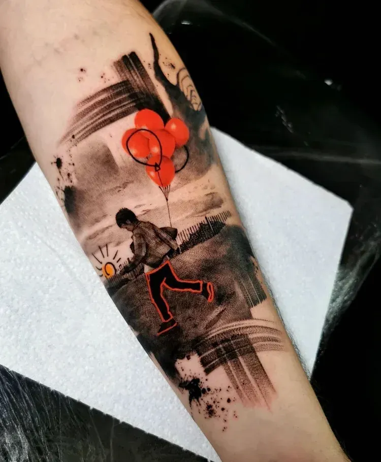 A tattoo of a person holding red balloons, depicted in a sketch-like, black and grey style with orange accents.