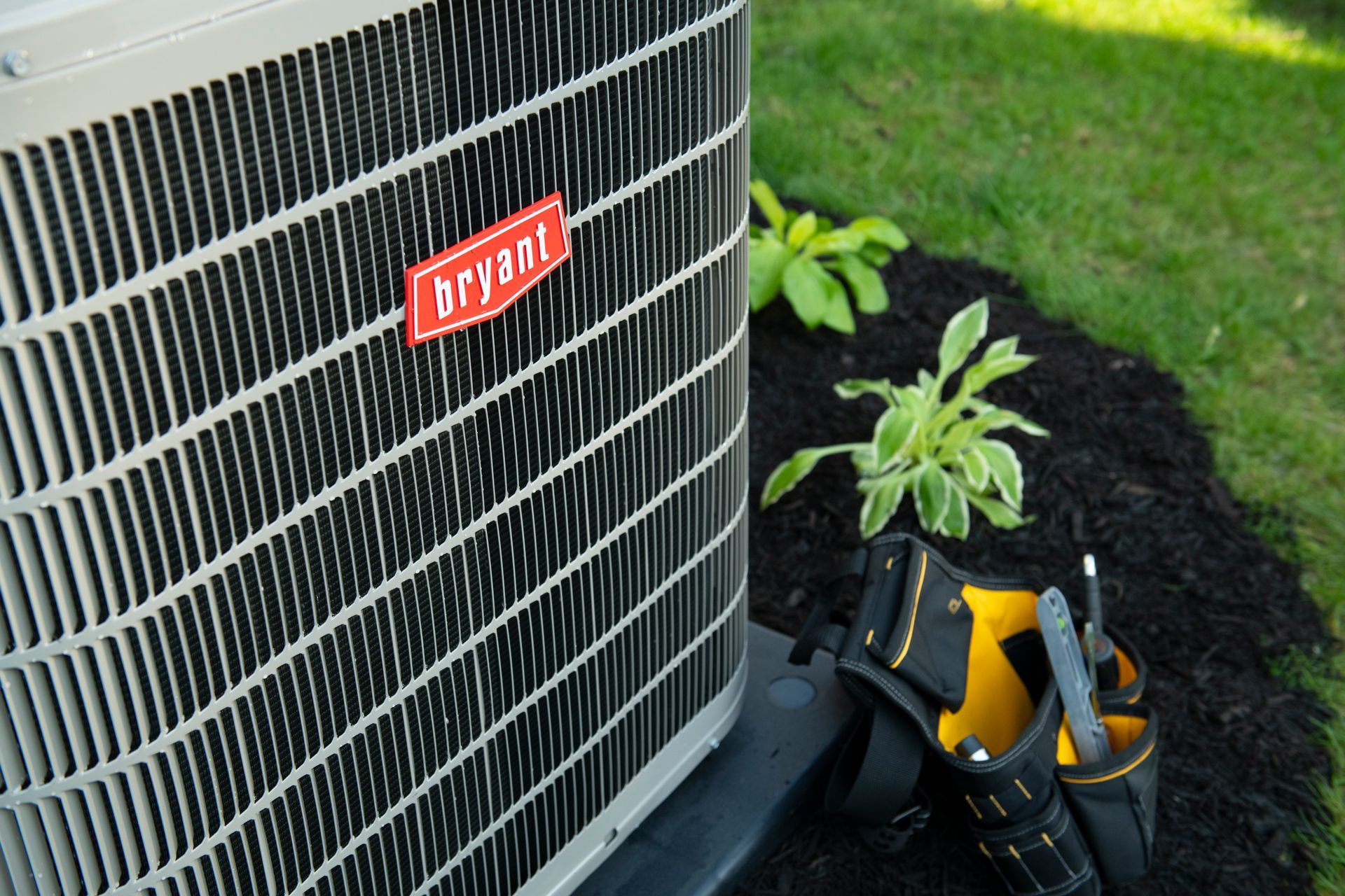 Person using a screwdriver to repair a white wall-mounted air conditioner unit.