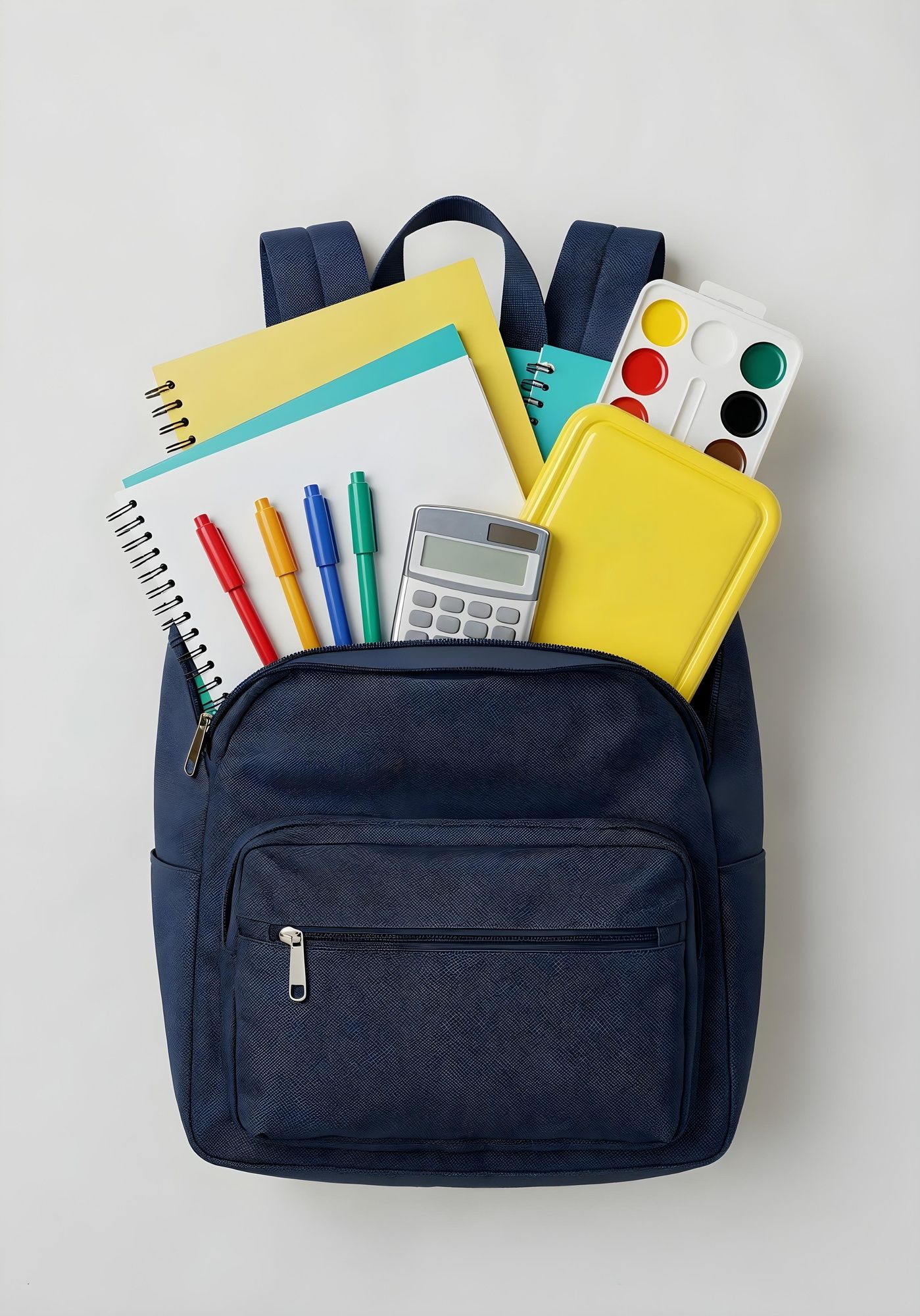 Mochila azul marino repleta de cuadernos, bolígrafos y material de arte sobre un fondo blanco.