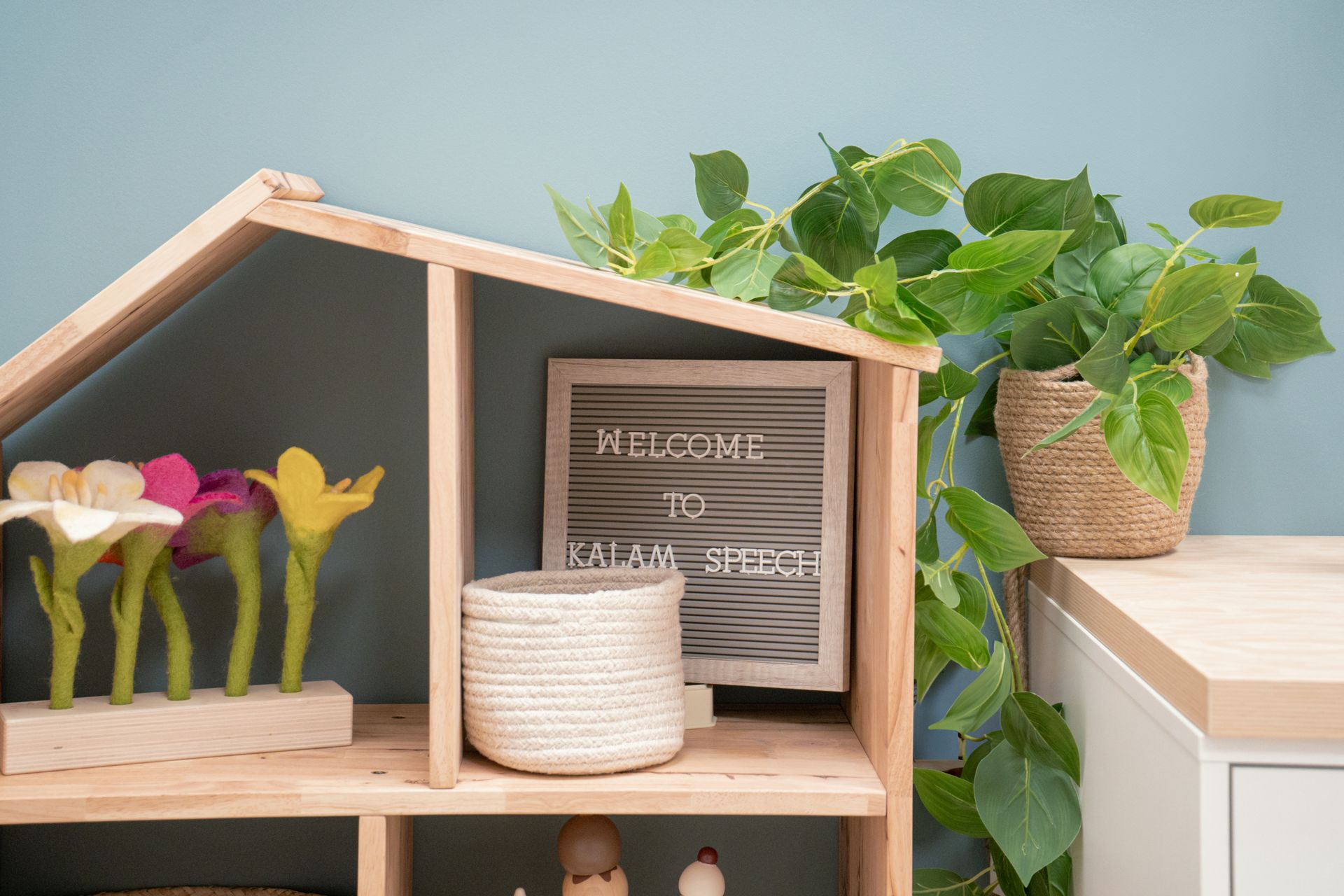 A wooden doll house is sitting on top of a wooden shelf.
