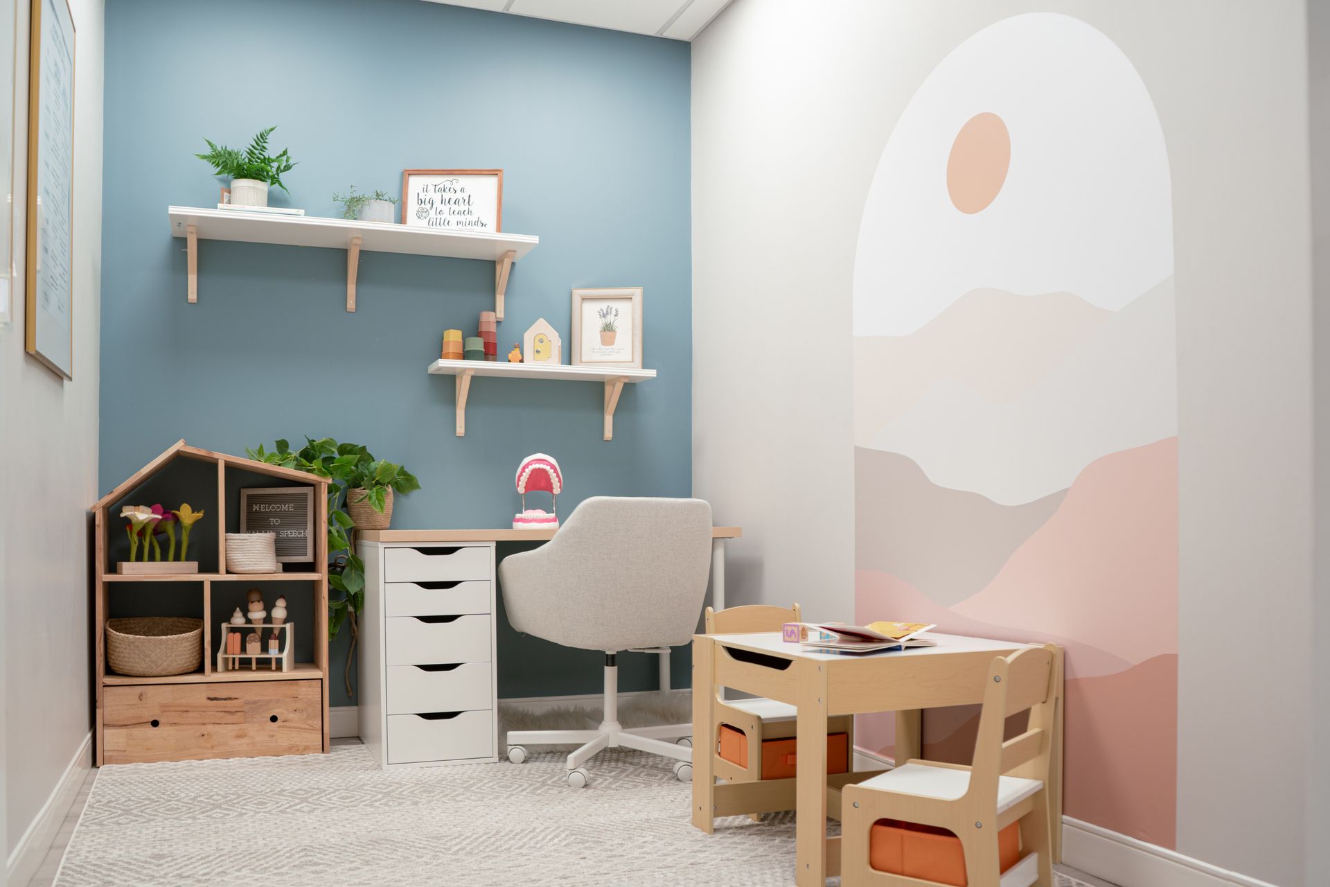 A room with a desk , chair , table and shelves.