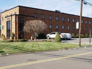 A large brick building with a white truck parked in front of it.