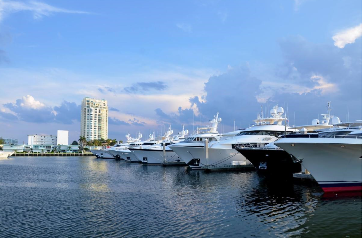 A white car is parked in front of a large brick building.