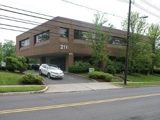 A man is giving a key to a woman while holding a model house.