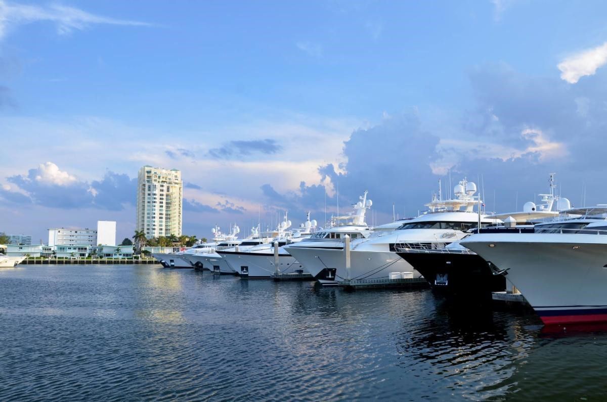 A man is signing a contract with a model house on a clipboard.