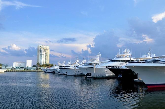 A man is signing a contract with a model house on a clipboard.