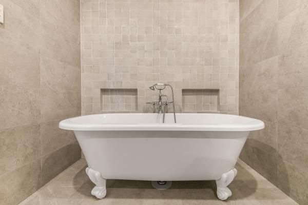A White Bathtub Is Sitting in A Bathroom Next to A Tiled Wall | Mid-North Coast, NSW | BDM Constructions