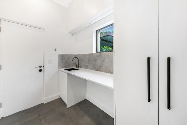 A Laundry Room with White Cabinets, a Sink, and A Window | Mid-North Coast, NSW | BDM Constructions