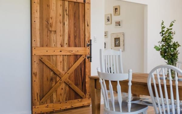 A Wooden Sliding Barn Door Is Open to A Dining Room with A Table and Chairs | Mid-North Coast, NSW | BDM Constructions
