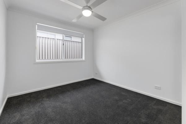 An Empty Bedroom with A Ceiling Fan and A Window | Mid-North Coast, NSW | BDM Constructions