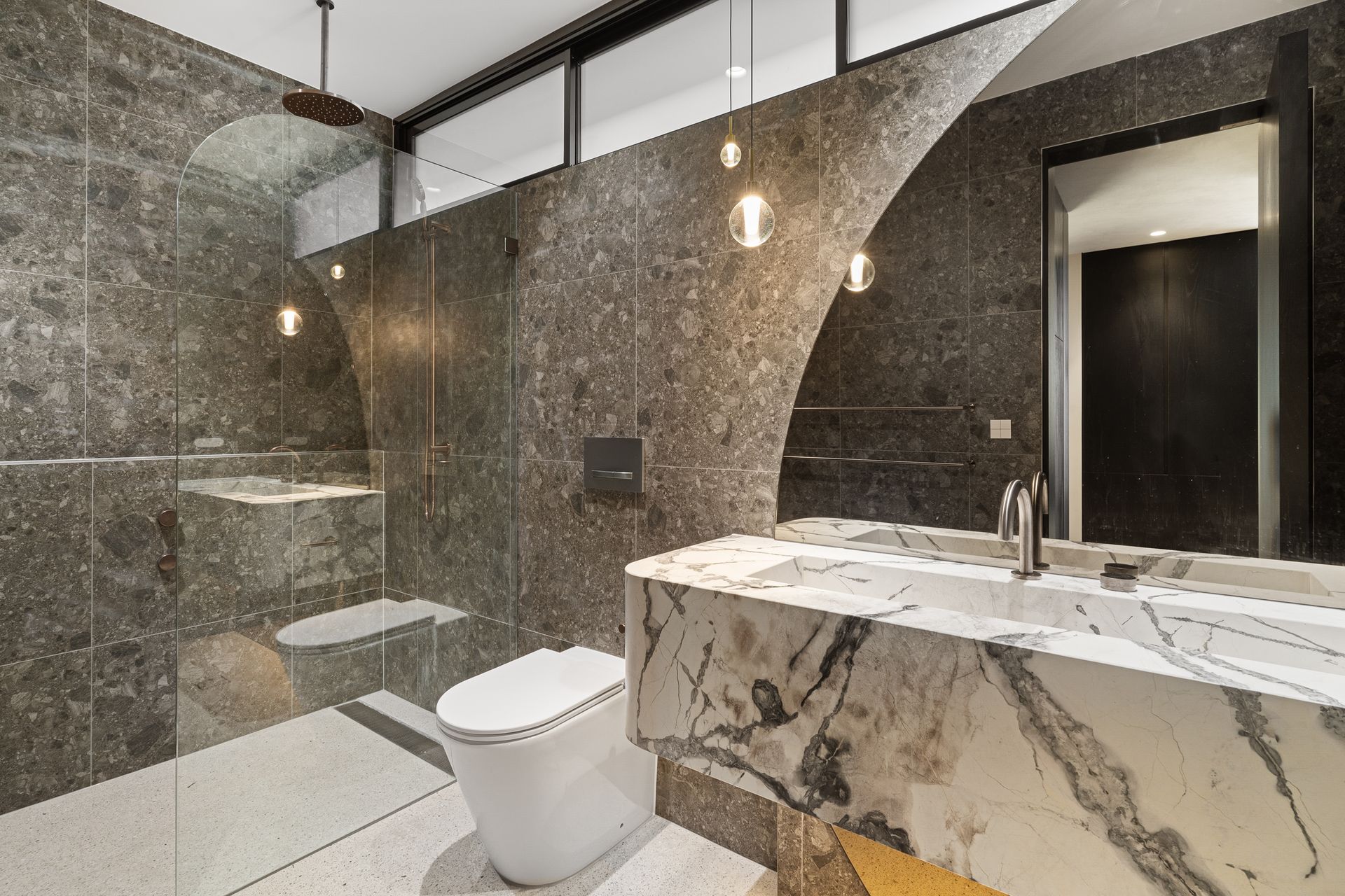 A bathroom with a toilet , sink , and shower.