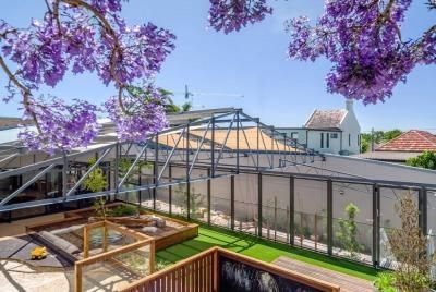A View of A Fenced in Yard with Purple Flowers and A House in The Background | Mid-North Coast, NSW | BDM Constructions