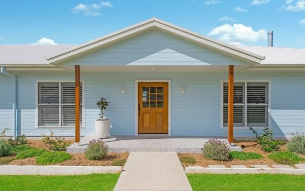 A Light Blue House with A Wooden Door and A Walkway Leading to It | Mid-North Coast, NSW | BDM Constructions