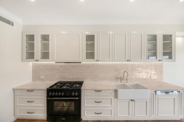 A Kitchen with White Cabinets and A Black Stove Top Oven | Mid-North Coast, NSW | BDM Constructions