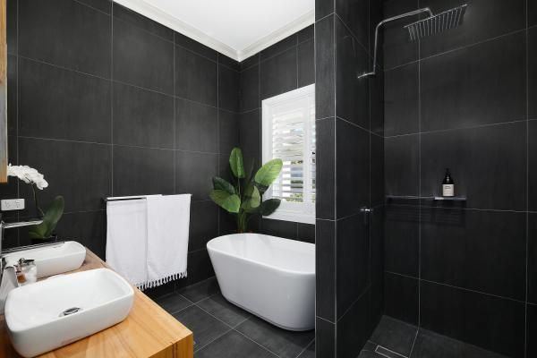 A Bathroom with Black Tiles, a Bathtub, Sink and Shower | Mid-North Coast, NSW | BDM Constructions
