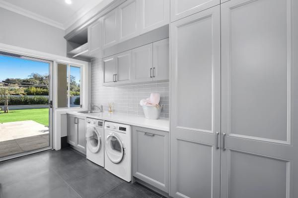 A Laundry Room with A Washer and Dryer , Cabinets, and A Sliding Glass Door | Mid-North Coast, NSW | BDM Constructions