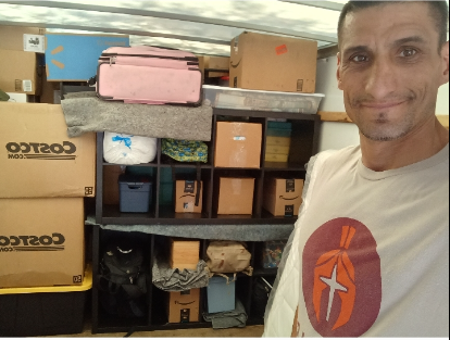 A man in a costco shirt is standing in front of boxes