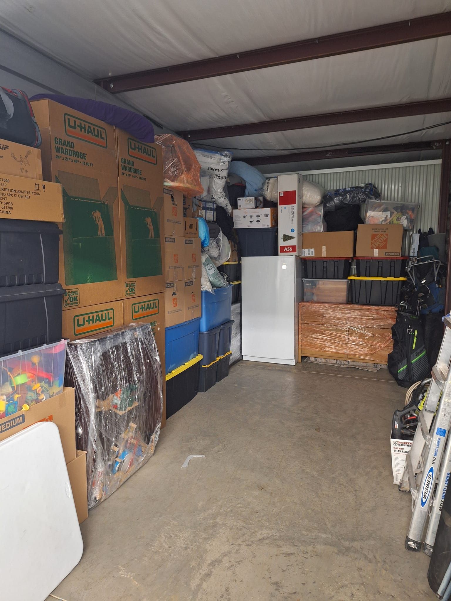 A warehouse filled with lots of boxes and a refrigerator.