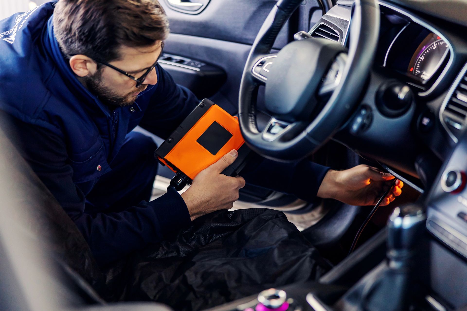 Un hombre está trabajando en el interior de un coche.