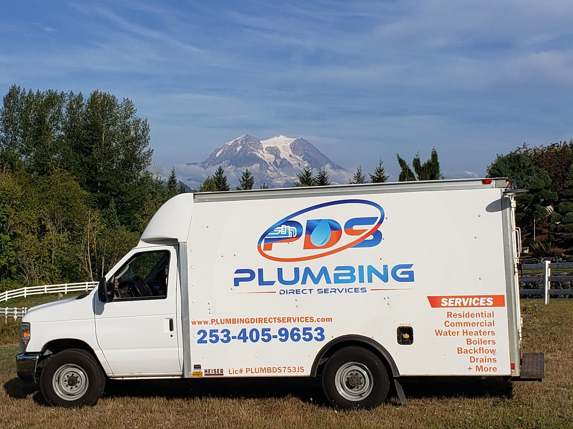 White 509 Plumbing service van parked outdoors with mountains in the background