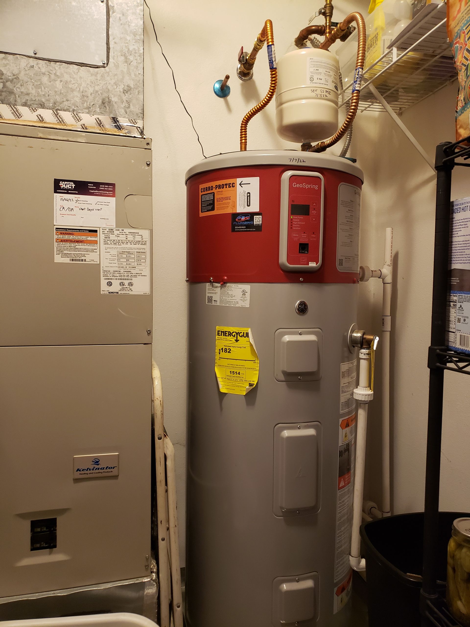 Utility room with a water heater, furnace, exposed pipes, and ductwork.