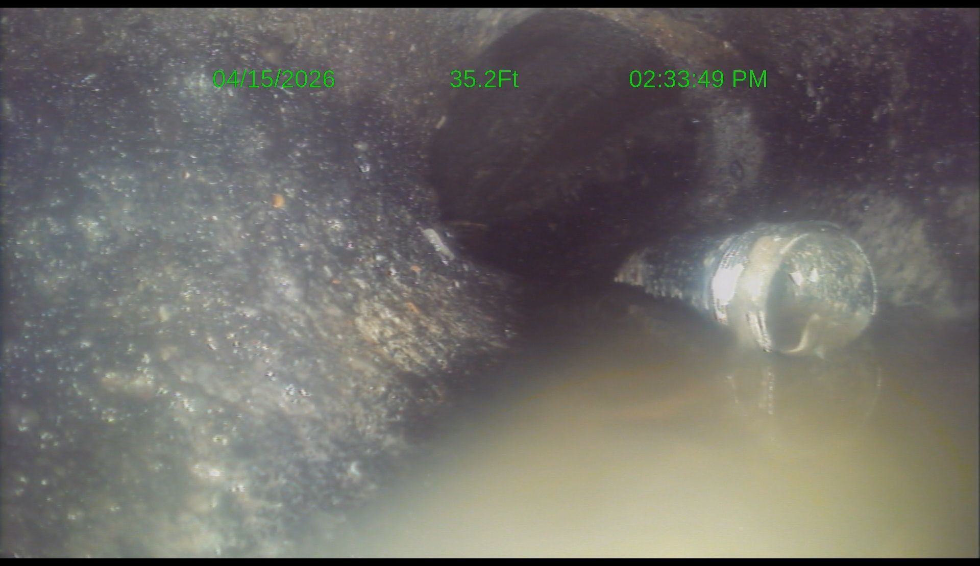 Foggy sewer pipe with a flashlight illuminating a dark, wet tunnel