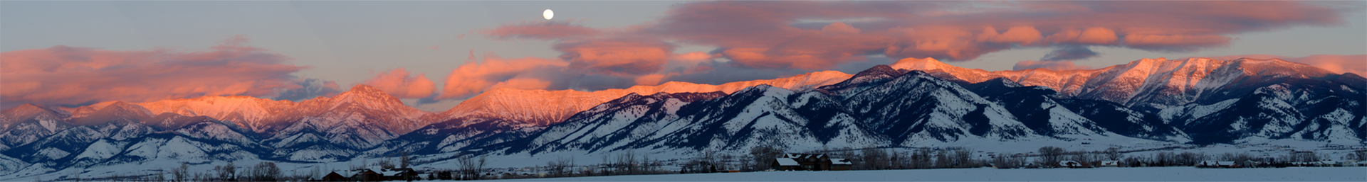 Mountains under a pink and orange sunset. A small, bright dot is above the peaks.
