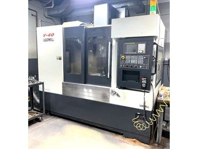 A large V-40 milling machine in a workshop setting. The machine is black and white, with a control panel on the right.