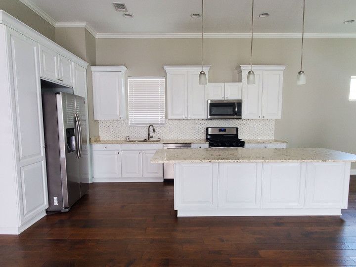 A kitchen with white cabinets and stainless steel appliances