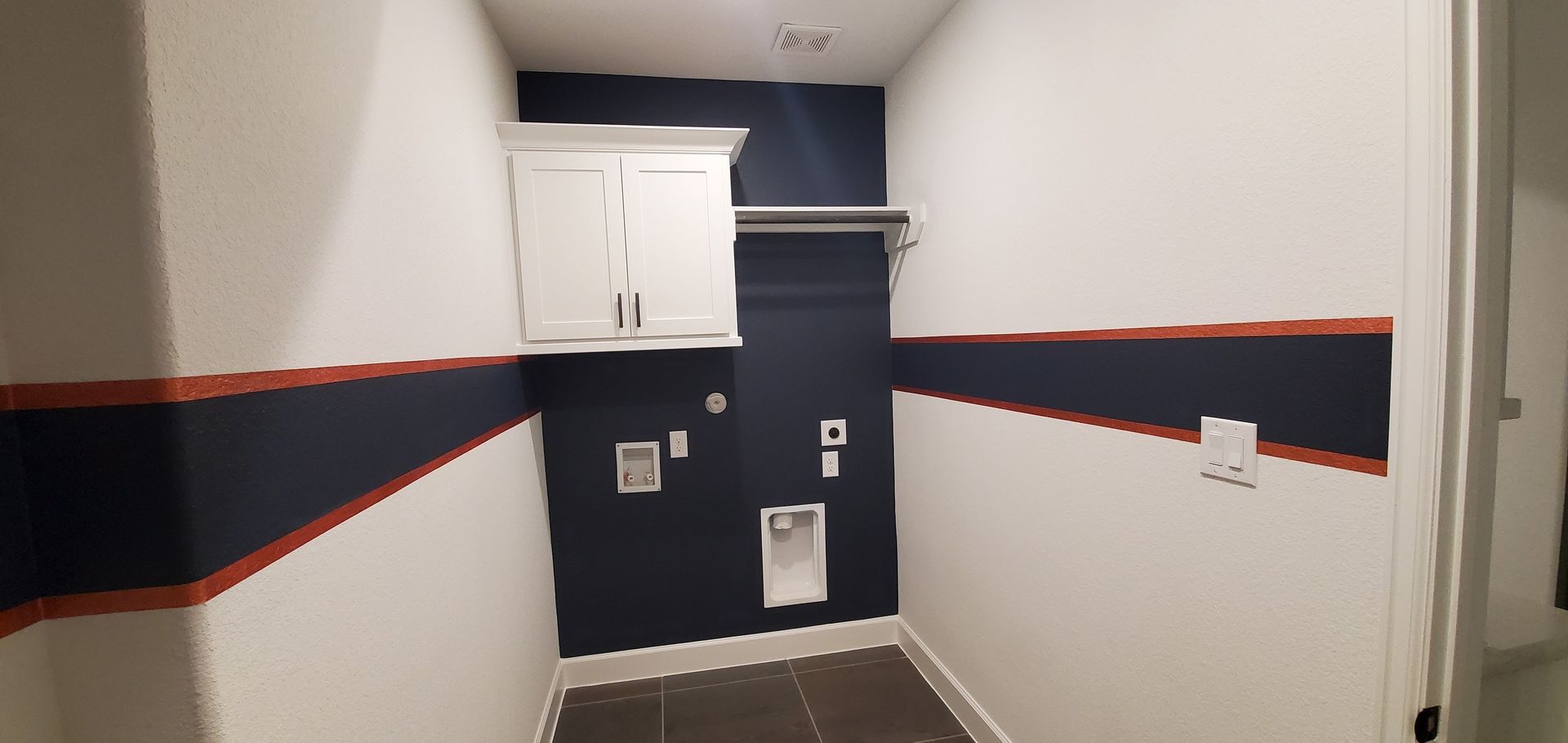 A laundry room with blue and white walls and a washer and dryer.