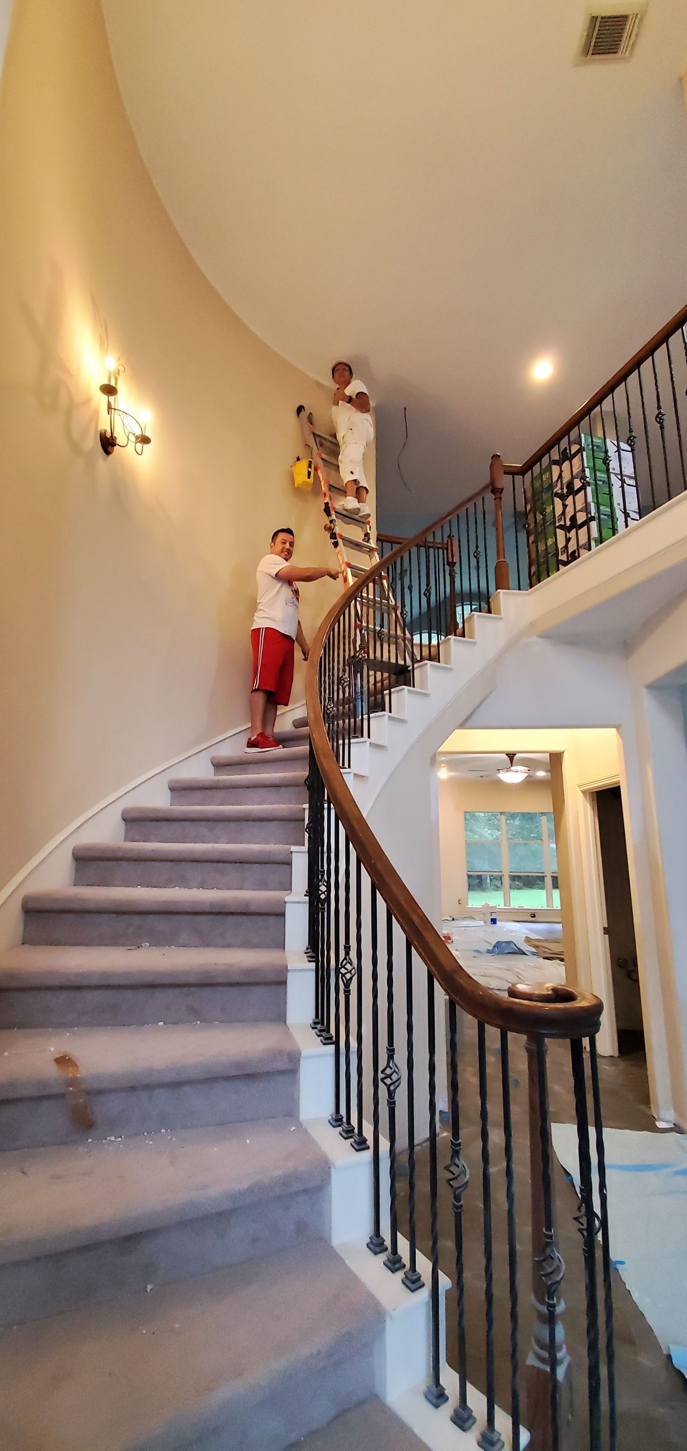 A man is standing on a set of stairs in a house.