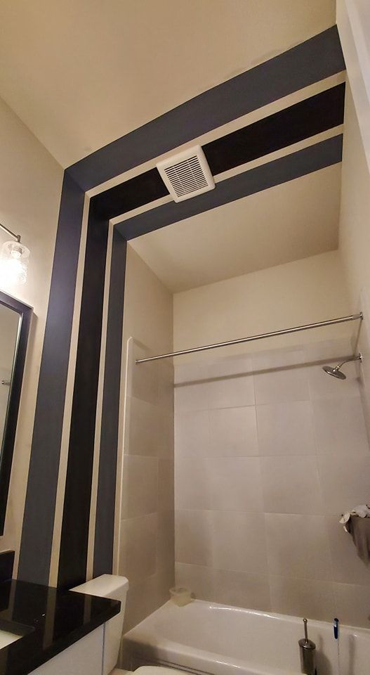 A bathroom with black and white stripes on the walls and ceiling.