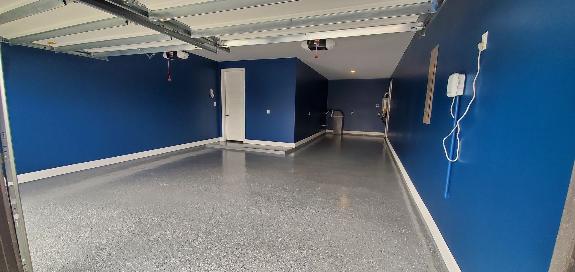 An empty garage with blue walls and a gray floor.