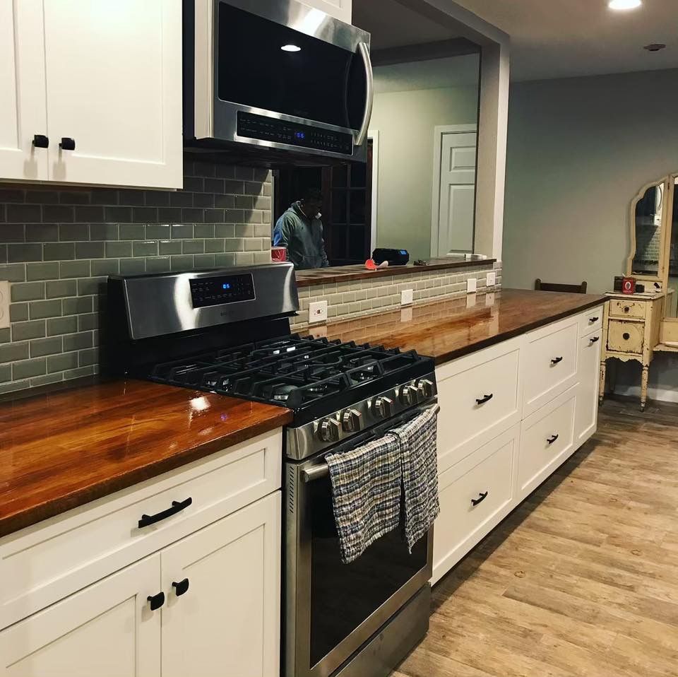 A kitchen with stainless steel appliances and wooden counter tops