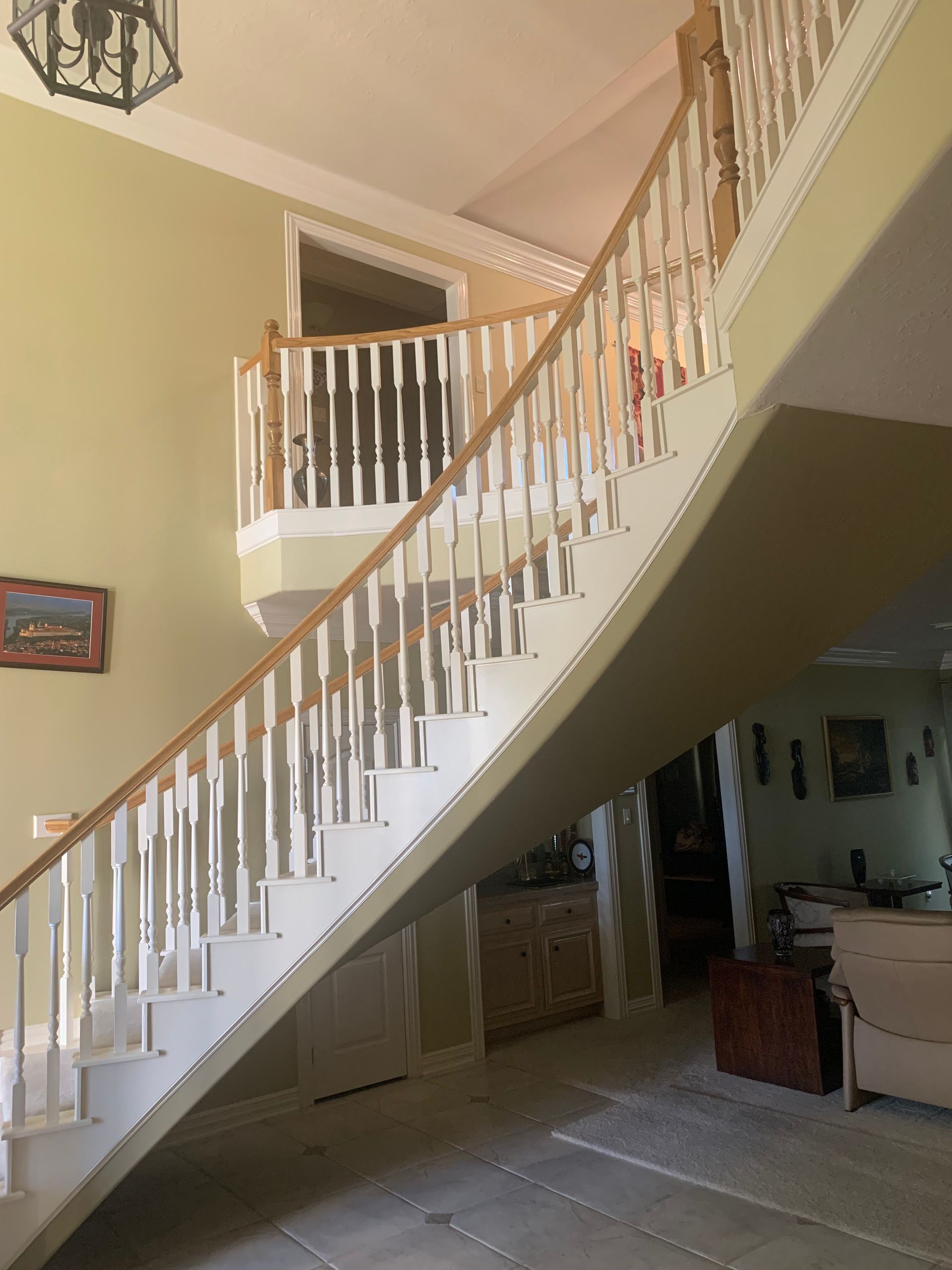 A curved staircase with a wooden railing in a living room
