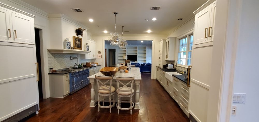 A kitchen with white cabinets and a large island in the middle of the room.